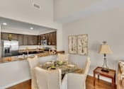 Thumbnail 5 of 12 - A modern kitchen with a dining table set for two.