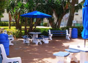 Thumbnail 15 of 18 - large tables with umbrellas outside at B'nai B'rith I, II, III deerfield apartments in deerfield beach, FL