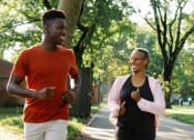 Thumbnail 5 of 8 - a young man and an older woman jogging down a sidewalk