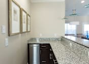 Thumbnail 26 of 33 - A kitchen with granite countertops and a stainless steel dishwasher.