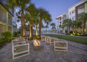 Thumbnail 21 of 44 - Fire pit lounge with ample seating by the green at Residencsa at The Green in Lakewood Ranch Bradenton