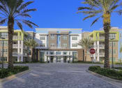 Thumbnail 41 of 44 - Exterior of Residences at The Green clubhouse with towering palms