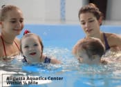 Thumbnail 19 of 57 - a family playing in the water in a swimming pool
