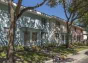 Thumbnail 6 of 32 - Pastel blue, white, and pink apartment homes with mature trees and neat sidewalks at Terraces at Clearwater Beach, Clearwater, FL