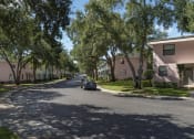 Thumbnail 3 of 32 - Tree-lined street with pastel colored apartment buildings at Terraces at Clearwater Beach, Clearwater, FL, 33756