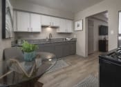 Thumbnail 22 of 32 - Kitchen with wood-style floors, white upper and gray lower cabinets, and stainless steel appliances at Terraces at Clearwater Beach, Clearwater, Florida
