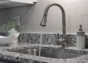 Thumbnail 23 of 32 - modern fixture with pull-down sprayer and under-mount sink in granite countertop in kitchen at Terraces at Clearwater Beach, Clearwater, Florida