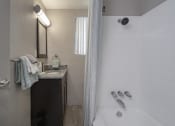 Thumbnail 29 of 32 - Bathroom with granite vanity countertop and over mirror lighting and shower/tub at Terraces at Clearwater Beach, Clearwater