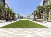 Thumbnail 19 of 44 - Green lawn area leading to pool at Residences at The Green in Lakewood Ranch, FL