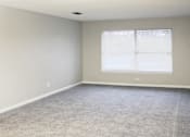 Thumbnail 6 of 8 - large carpeted living room with a wide window and mini blinds at The Bluffs Apartments in Jasper, AL