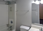 Thumbnail 7 of 8 - Bathroom with sink vanity, mirror and light kit, toilet, and tub/shower at The Bluffs Apartments