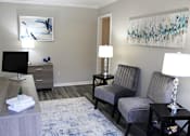 Thumbnail 1 of 8 - the leasing office with guest seating and desk at The Bluffs Apartments in Jasper, AL