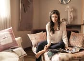 Thumbnail 3 of 8 - a woman sitting on a couch looking at a magazine