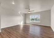 Thumbnail 3 of 24 - an empty living room with a ceiling fan and a window