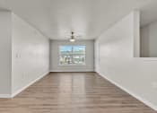 Thumbnail 4 of 24 - an empty living room with a ceiling fan and a window