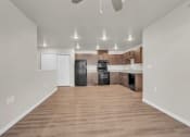Thumbnail 2 of 24 - an empty living room with a kitchen with black appliances