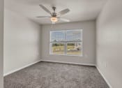 Thumbnail 5 of 24 - an empty room with a large window and a ceiling fan