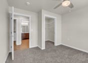 Thumbnail 6 of 24 - a bedroom with a closet and a ceiling fan