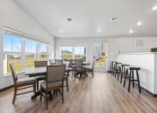 Thumbnail 17 of 24 - a dining room with tables and chairs and a bar and a kitchen