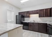 Thumbnail 36 of 57 - an empty kitchen with black appliances and marble counter tops