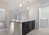 Thumbnail 30 of 57 - a renovated kitchen with a counter top and a laundry room