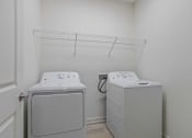 Thumbnail 31 of 57 - a washer and dryer in a laundry room with a rack on the wall
