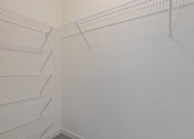 Thumbnail 29 of 57 - a walk in closet with white walls and empty shelves