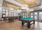 Thumbnail 14 of 57 - a pool table in a clubhouse with chairs and tables