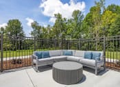Thumbnail 6 of 57 - a patio with couches and a table in front of a fence