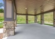 Thumbnail 53 of 57 - a covered parking area with stone pillars and a metal roof