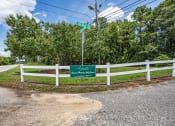 Thumbnail 47 of 57 - a white fence and a green sign on the side of a road