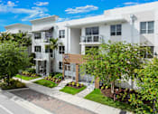 Thumbnail 39 of 40 - A modern apartment building with a well-maintained garden in front.