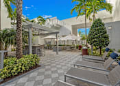 Thumbnail 38 of 40 - A patio with a checkered floor and several chairs and umbrellas.