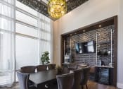 Thumbnail 13 of 44 - Wine tasting room with wine chandelier, tv, and table with chairs at Residences at The Green in Lakewood Ranch, FL