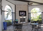 Thumbnail 31 of 40 - Outdoor lounge with fireplace, TV, and tables and chairs in Orlando, FL 32827
