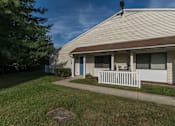 Thumbnail 5 of 9 - A house with a white picket fence and a tree in the front yard.