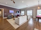 Thumbnail 63 of 197 - A living room with a white couch and a television on the wall at Foxwood Apartments, Raleigh-Durham, NC