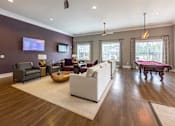 Thumbnail 64 of 197 - A living room with a white couch and a wooden floor at Foxwood Apartments, North Carolina, 27616