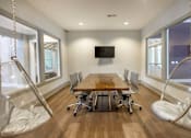 Thumbnail 54 of 197 - A conference room with a wooden table and chairs at Foxwood Apartments, Raleigh-Durham