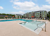 Thumbnail 5 of 197 - A large swimming pool with a slide in front of a building at Foxwood Apartments, Raleigh-Durham, North Carolina