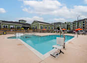 Thumbnail 8 of 197 - A swimming pool with a slide and a sun lounger at Foxwood Apartments, Raleigh-Durham, NC