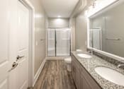 Thumbnail 126 of 197 - A bathroom with a toilet, sink, mirror, and shower at Foxwood Apartments, Raleigh-Durham, NC