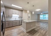 Thumbnail 102 of 197 - A kitchen with a refrigerator on the left and a counter with a sink at Foxwood Apartments, Raleigh-Durham, NC