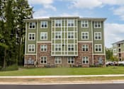 Thumbnail 190 of 197 - A large apartment building with a green and grey exterior at Foxwood Apartments, North Carolina, 27616