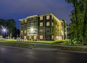 Thumbnail 155 of 197 - A large building with a greenish hue is illuminated at night at Foxwood Apartments, Raleigh-Durham, North Carolina