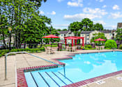 Thumbnail 11 of 31 - A pool with a slide and a red umbrella.