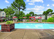 Thumbnail 10 of 31 - A pool surrounded by a red fence and trees.