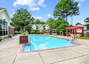 Thumbnail 12 of 31 - A pool surrounded by a red fence and a red gazebo.