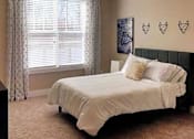 Thumbnail 96 of 197 - A bedroom with a bed, pillows, and a window with curtains at Foxwood Apartments, Raleigh-Durham, NC, 27616
