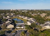 Thumbnail 3 of 15 - Aerial view of community with lake in the middle of buildings